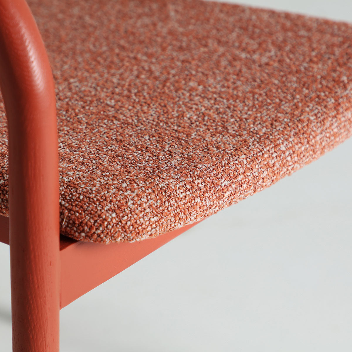 Silla fabricada en madera de fresno rojo con tejido poliéster naranja.