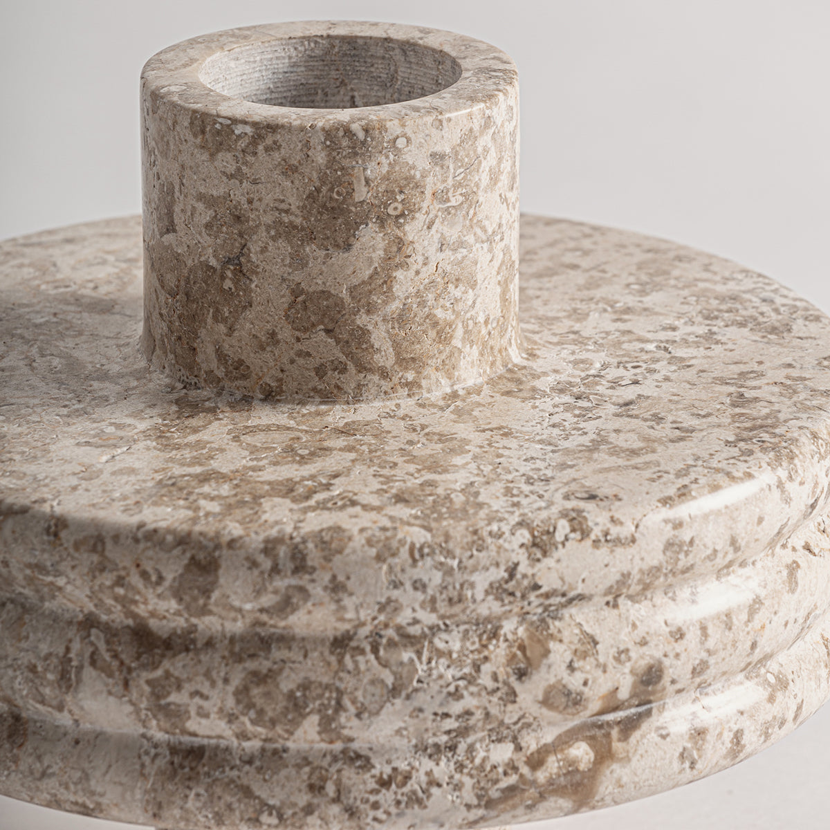 Jarrón fabricado de mármol color beige, acabado mate.