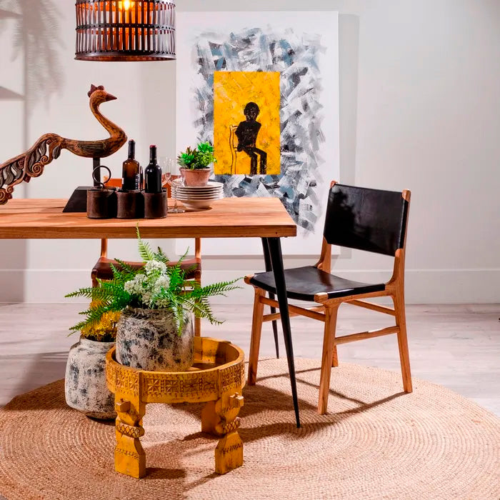 Silla color negro, fabricada en madera maciza de teca color natural y piel.