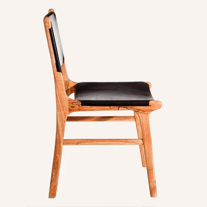 Silla color negro, fabricada en madera maciza de teca color natural y piel.