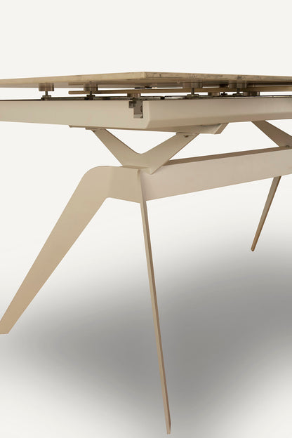 Mesa comedor Lula, rectangular y extensible, en color blanco con pie metálico blanco. Fabricada de cerámica y metal.