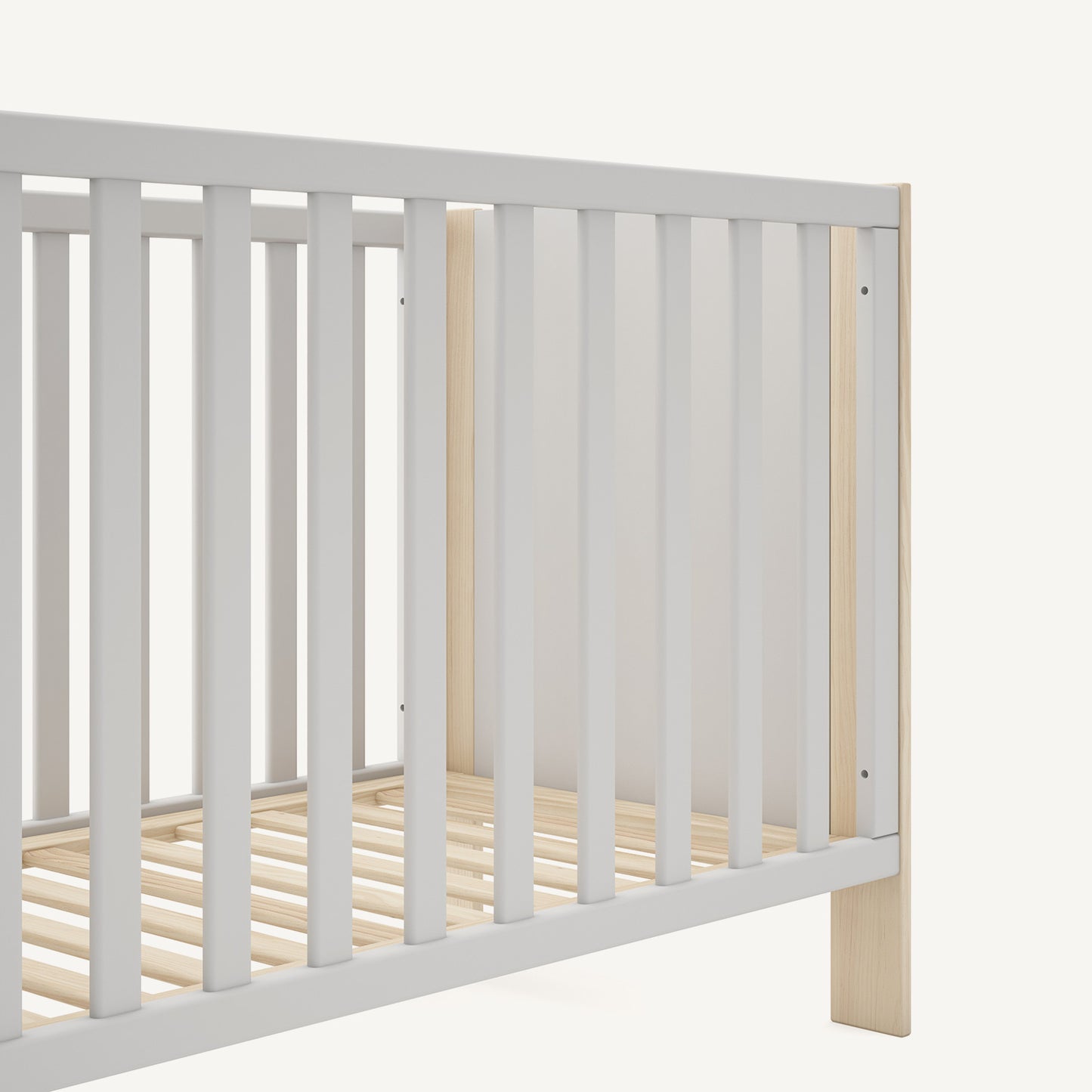 Detalle de cuna de bebé con barrotes y acabado en blanco y madera