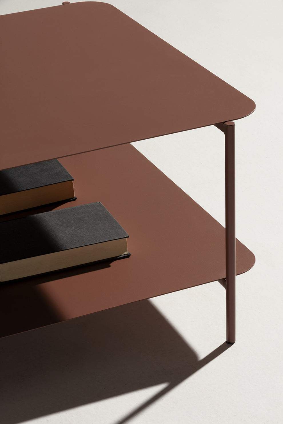 Mesa cuadrada de metal en tonos rojizos