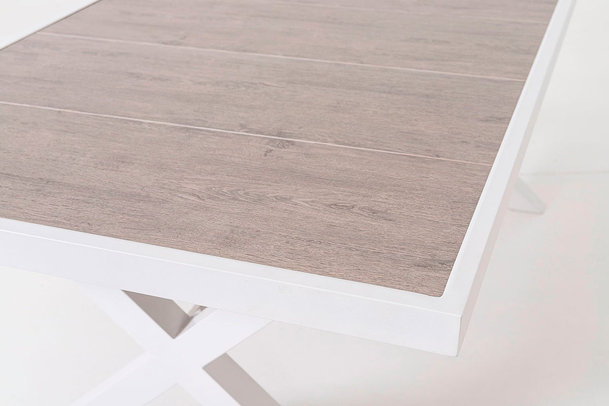 Mesa de comedor exterior, fabricada de aluminio blanco y tapa de cerámica efecto madera.