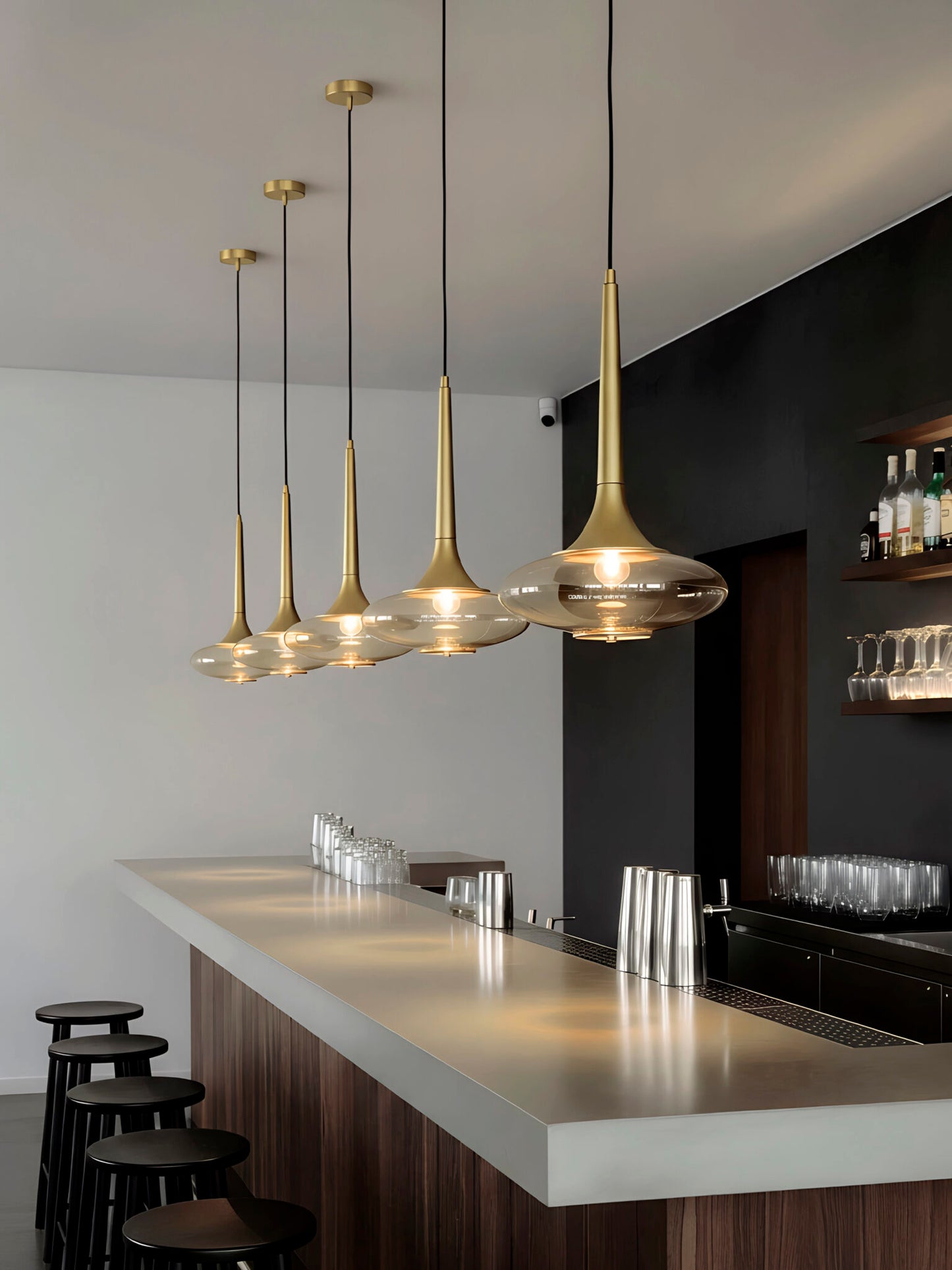 Lámpara de techo o colgante, en color oro. Fabricada de acero con un portalámparas de cristal ahumado.