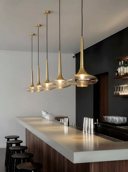 Lámpara de techo o colgante, en color oro. Fabricada de acero con un portalámparas de cristal ahumado.