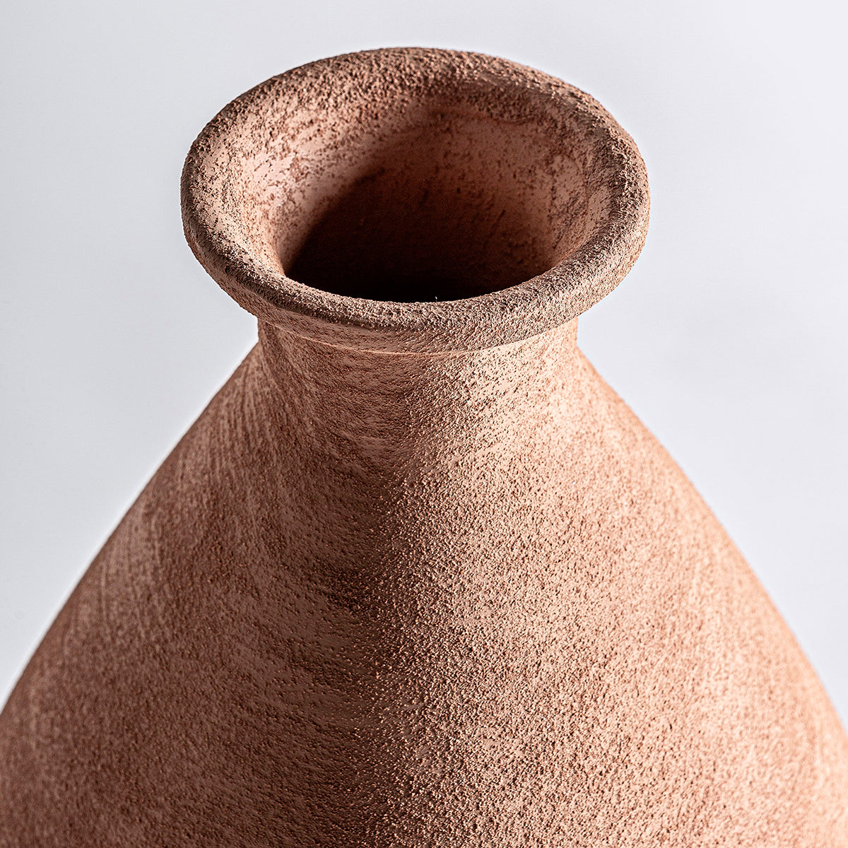 Jarrón en color marrón con acabado texturizado, fabricado entero de cerámica.