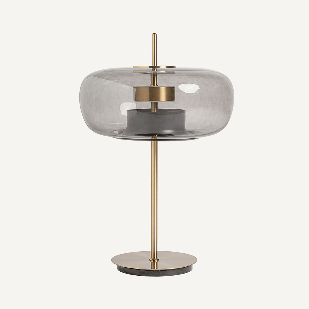 Lámpara de mesa fabricada de cristal gris ahumado y metal acrílico color oro. De luz LED