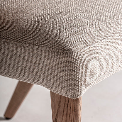 Silla fabricada en madera de roble color marrón claro, con tapicería hidrófuga y antimanchas. Sin brazos