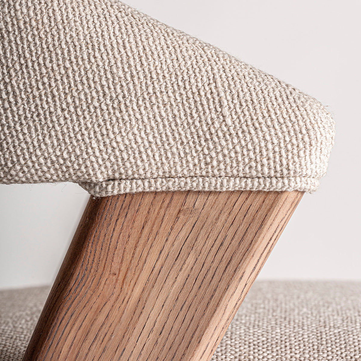 Silla fabricada en madera de roble color marrón claro, con tapicería hidrófuga y antimanchas. Sin brazos