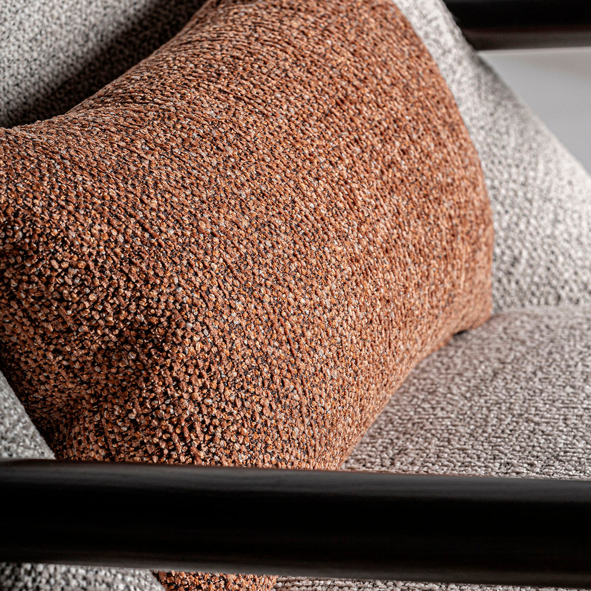 Sillón fabricado en madera de pino, metal negro y tejido poliéster con acabado jaspeado, color beige y marrón.