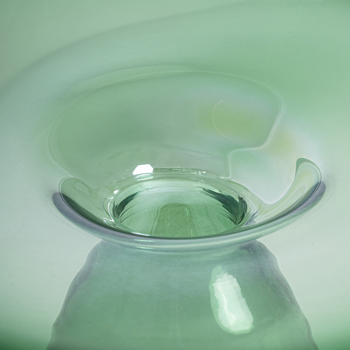 Jarrón fabricado de vidrio en color verde con acabado traslúcido. Estilo contemporáneo