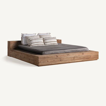 Cama de madera artesanal que aporta calidez y equilibrio al dormitorio