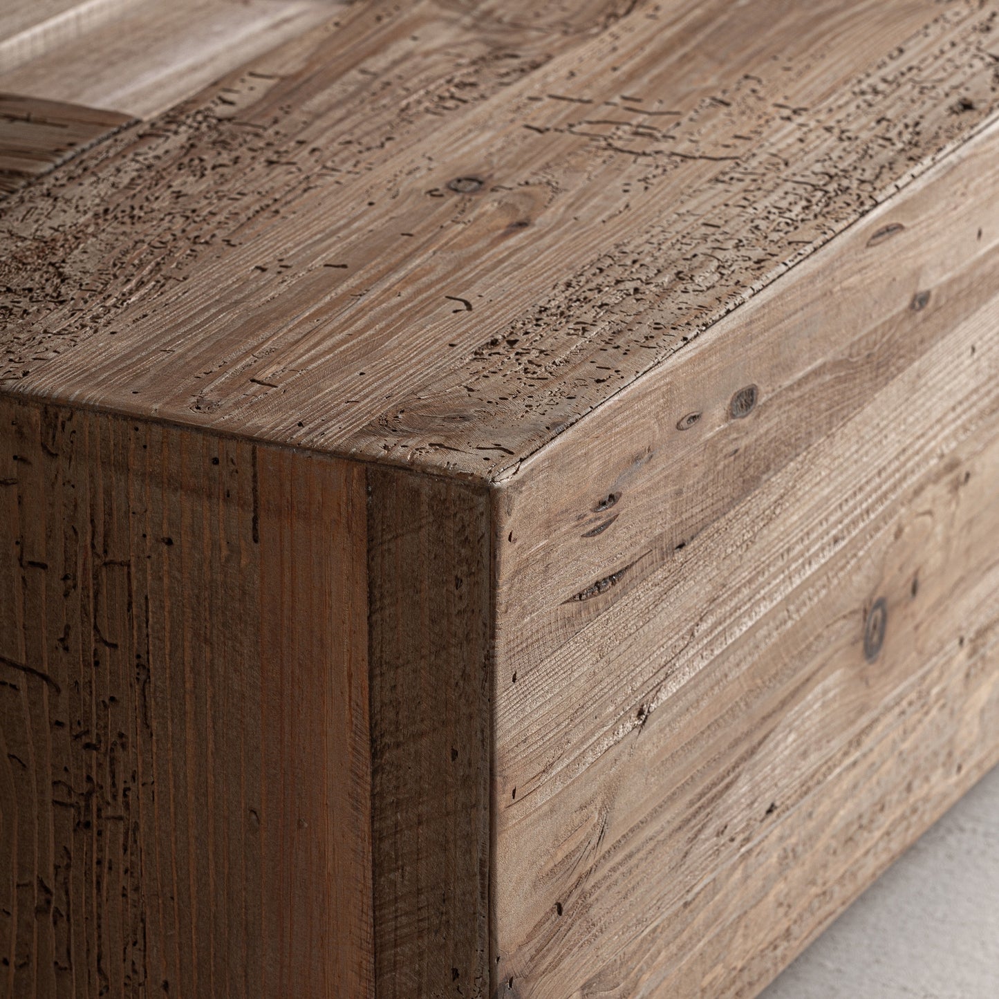 Detalle de cama de pino reciclado con acabado natural y vetas visibles