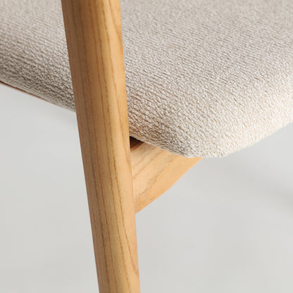 Detalle de silla Eriswil con estructura de madera y asiento acolchado claro
