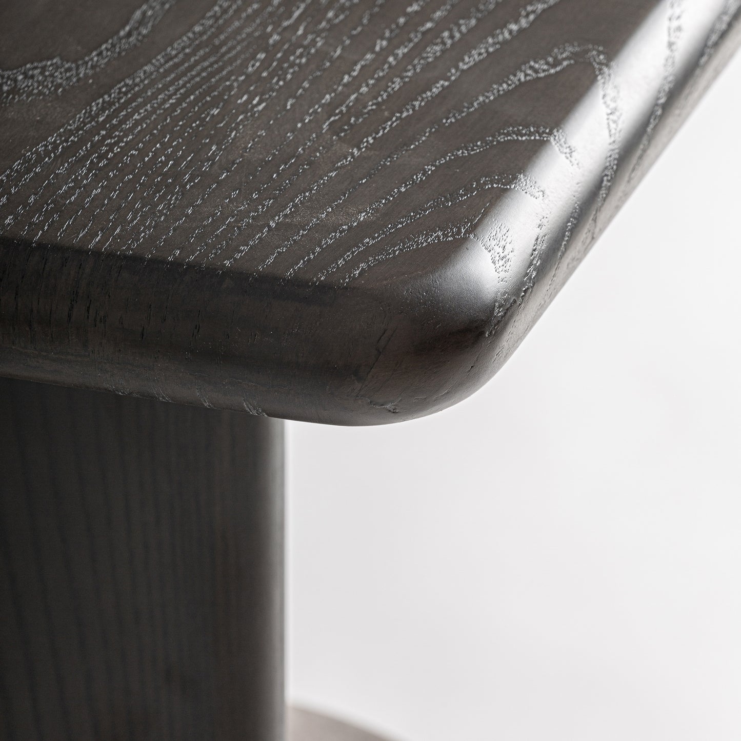 Mesa auxiliar en madera oscura con base a media altura en travertino