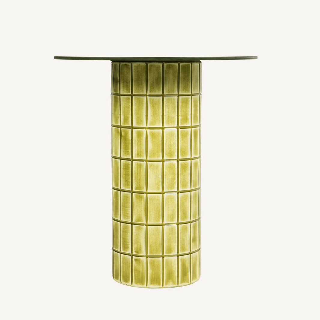 Mesa auxiliar circular en tonos verdes y amarillos vibrantes.