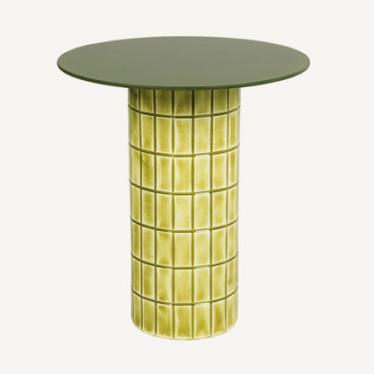 Mesa auxiliar circular en tonos verdes y amarillos vibrantes.