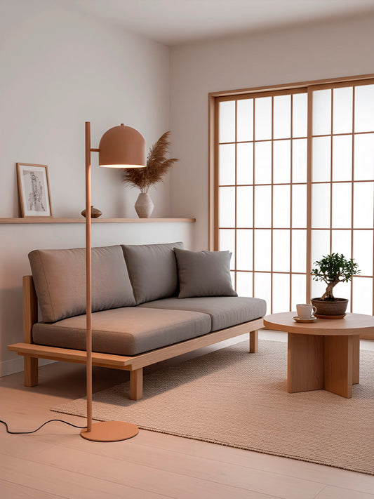 Lámpara de pie en color teja, fabricada de acero con un portalámparas.