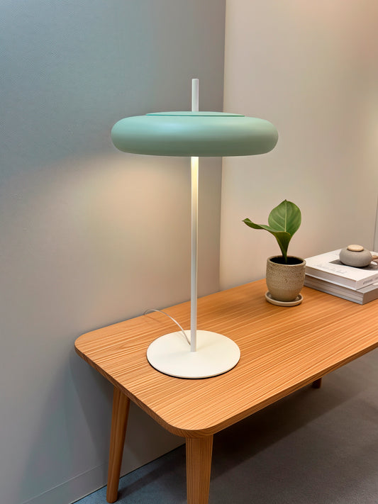 Lámpara de mesa en color verde y crema, fabricada de acero.