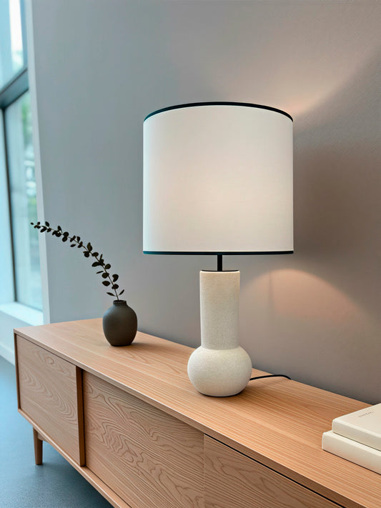 Lámpara de mesa en color blanco y negro, fabricada de acero y tejido en pantalla.