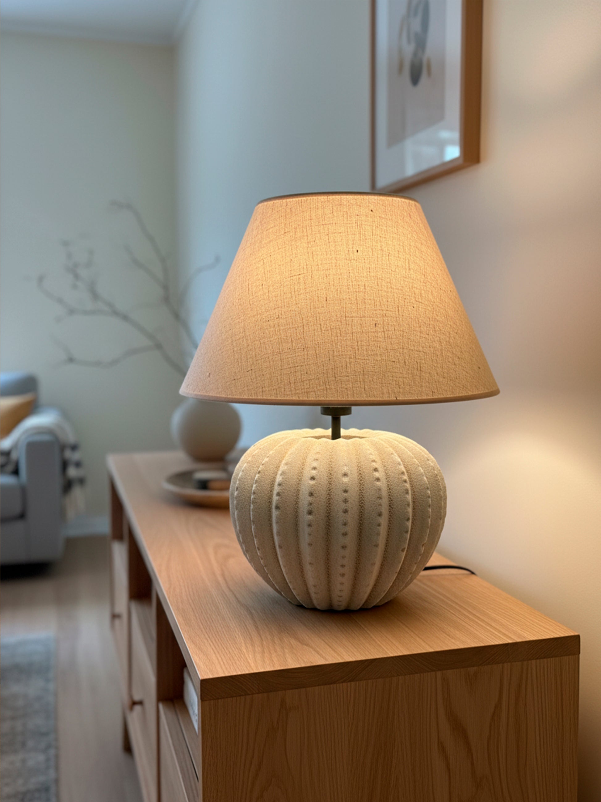 Lámpara de mesa en color beige y marrón, fabricada de acero, cerámica y tejido en pantalla.