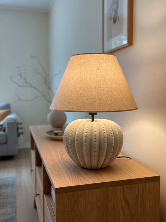 Lámpara de mesa en color beige y marrón, fabricada de acero, cerámica y tejido en pantalla.