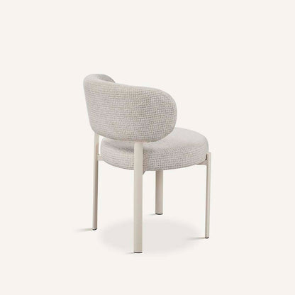 Silla para el salón o comedor, con asiento tapizado en color gris, respaldo redondeado y patas de metal color blanco.