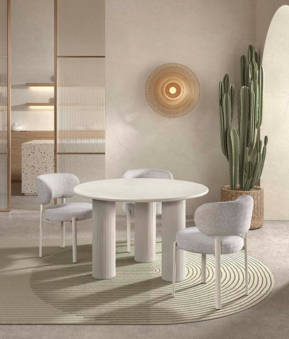 Silla para el salón o comedor, con asiento tapizado en color gris, respaldo redondeado y patas de metal color blanco.