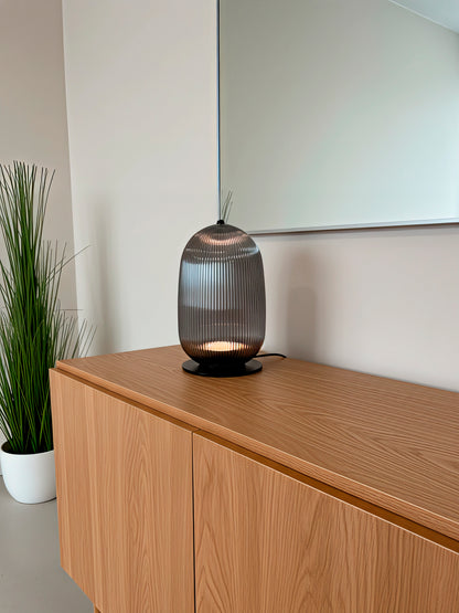 Lámpara de mesa en color negro de cristal rayado.