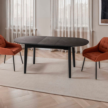 Mesa de comedor ovalada y extensible, en color negro con vetas blancas. Fabricada de metal combinada con tapa de porcelánico negro.