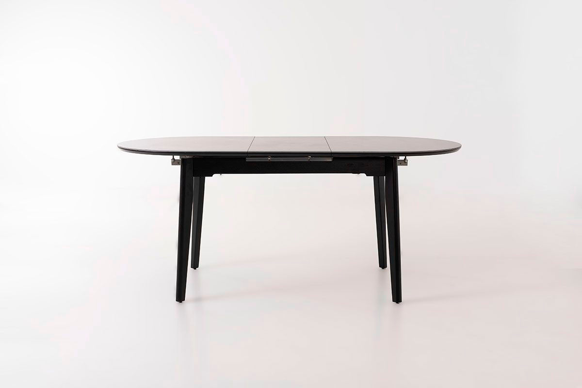 Mesa de comedor ovalada y extensible, en color negro con vetas blancas. Fabricada de metal combinada con tapa de porcelánico negro.